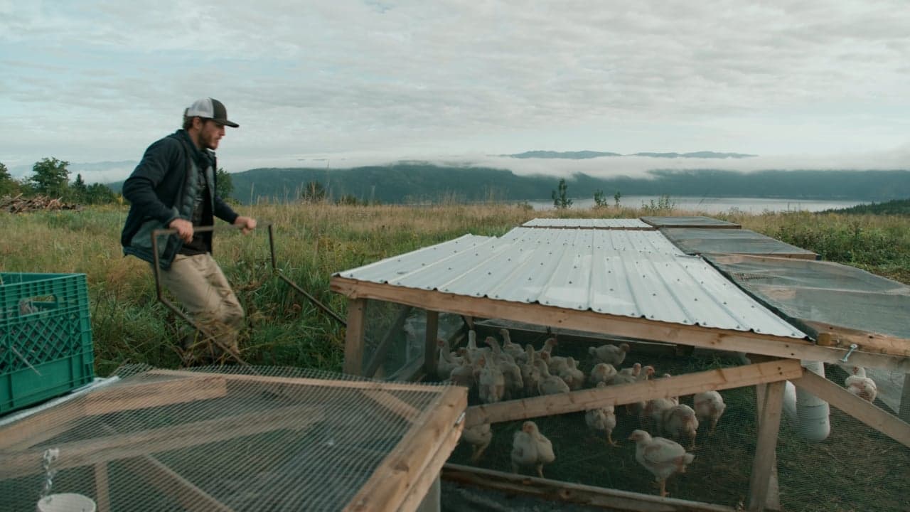 Farmer in front of farm structures